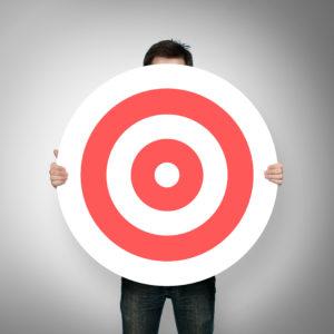 Man holds bullseye target in front of himself